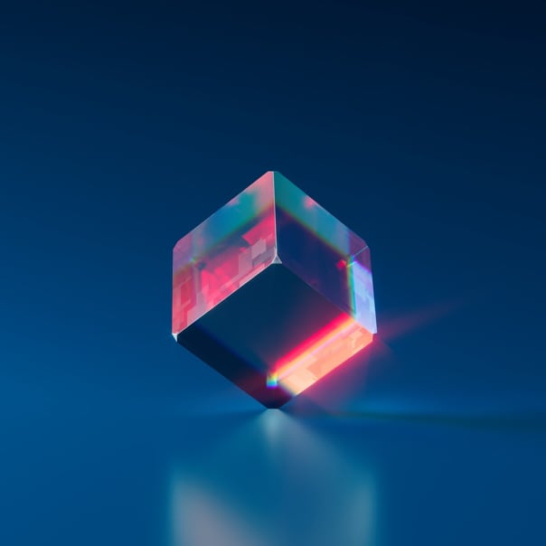 A shimmering cube floats on a reflective surface.